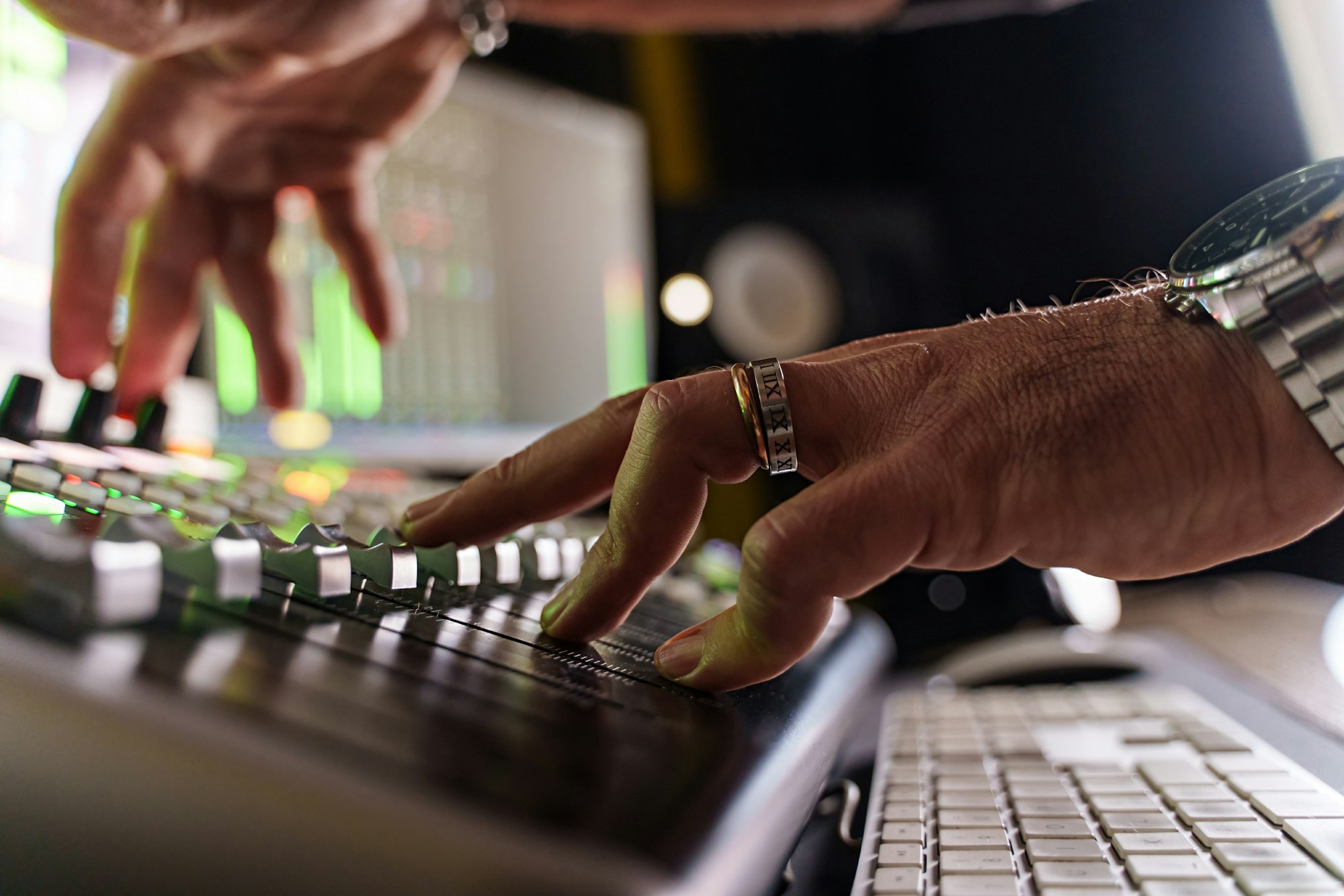 Close-up of caucasian music producer fading volume on sound mixer control panel